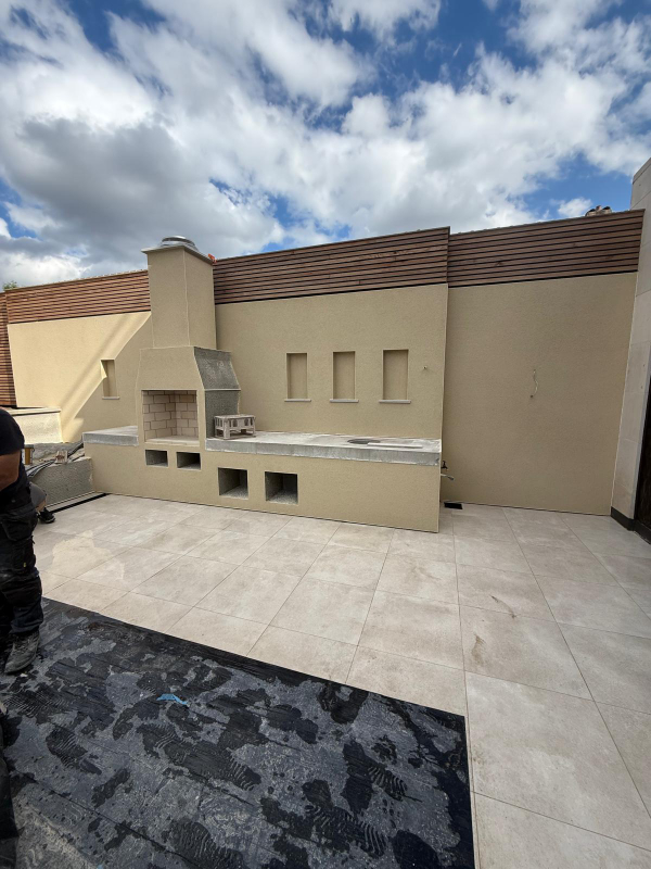 Monocouche render in ivory to garden walls and bbq area at Clapham, London. Rowland & Wyllie Plastering